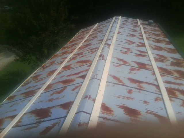 Rusted metal roof panels with new wood purlins before replacement — Storm Damage Roof Repair in Quincy by Roofing Brothers