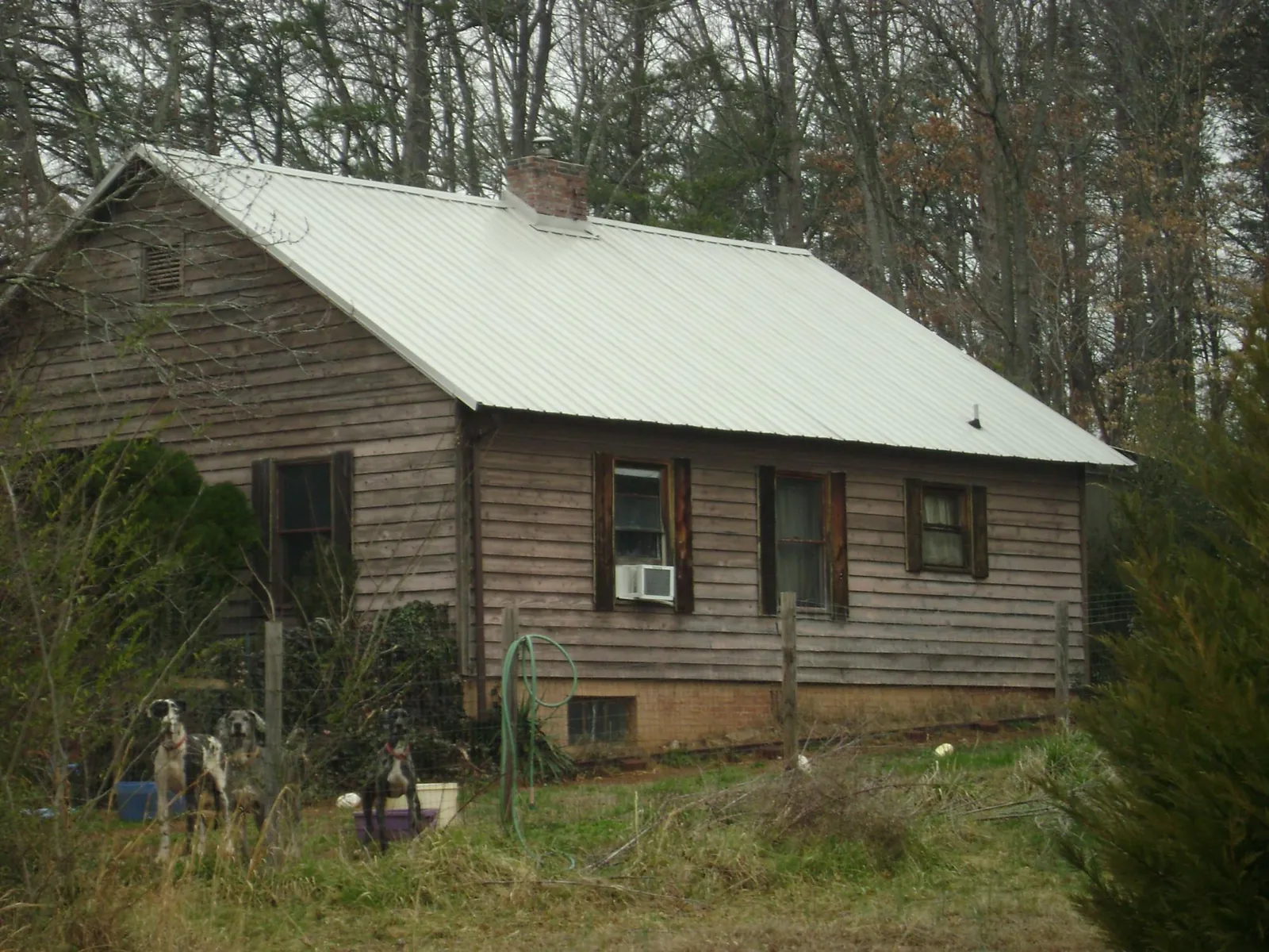 White metal roof on an old wood sided farmhouse, from a Metal Roof Installation job in Quincy